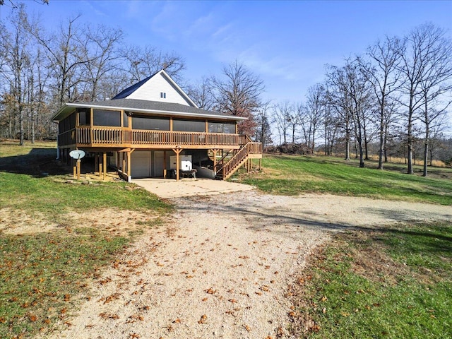 view of front of home with a garage, a deck, and a front yard