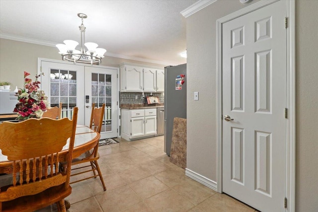 kitchen with white cabinets, decorative light fixtures, and crown molding