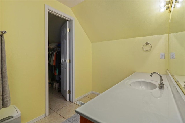 bathroom with tile patterned floors, vanity, toilet, and lofted ceiling