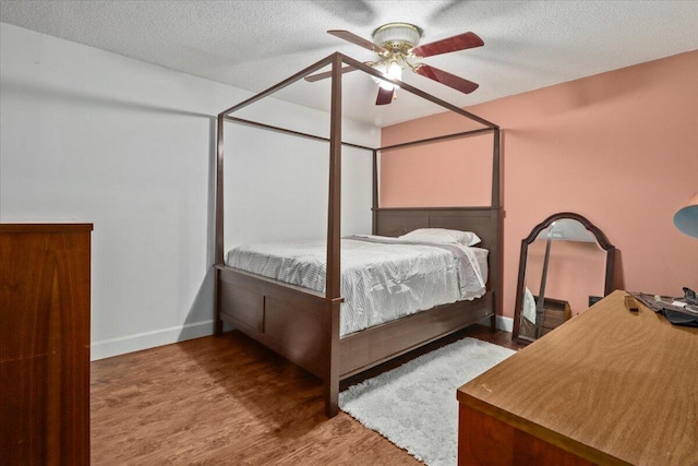 bedroom with a textured ceiling, hardwood / wood-style flooring, and ceiling fan