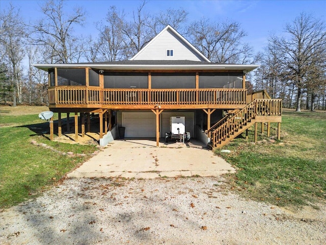 view of front of home with a sunroom, a garage, a deck, and a front lawn