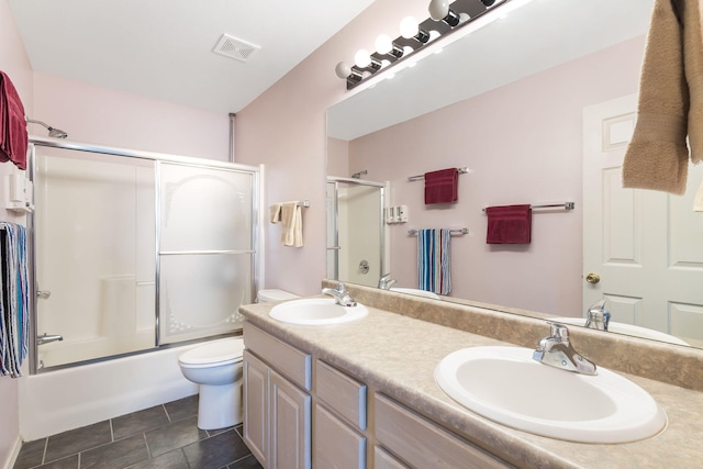 full bathroom featuring tile patterned floors, toilet, combined bath / shower with glass door, and vanity