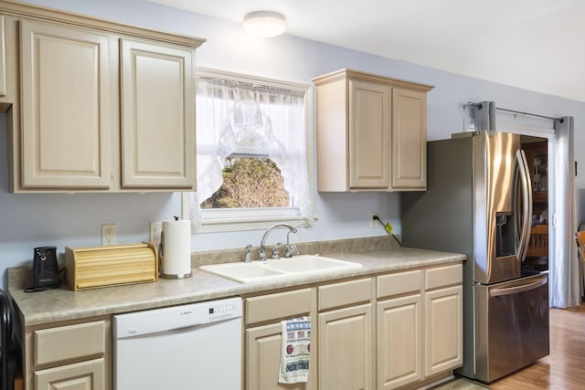 kitchen featuring stainless steel fridge, sink, white dishwasher, and light hardwood / wood-style floors