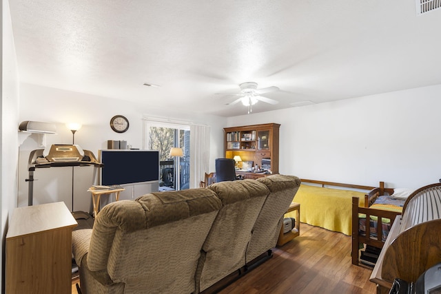 living room featuring a textured ceiling, ceiling fan, and dark hardwood / wood-style floors