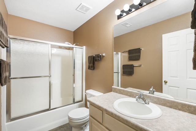 full bathroom with vanity, enclosed tub / shower combo, and toilet