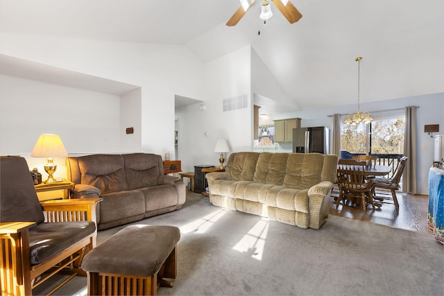 living room with ceiling fan with notable chandelier, dark hardwood / wood-style flooring, and high vaulted ceiling