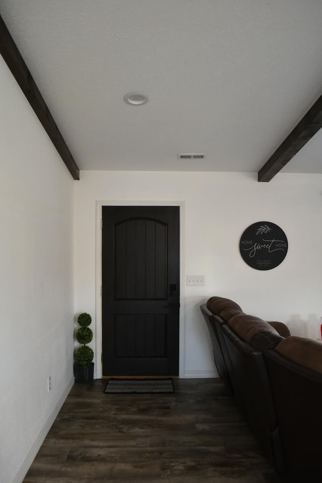 entrance foyer featuring beamed ceiling and dark hardwood / wood-style flooring