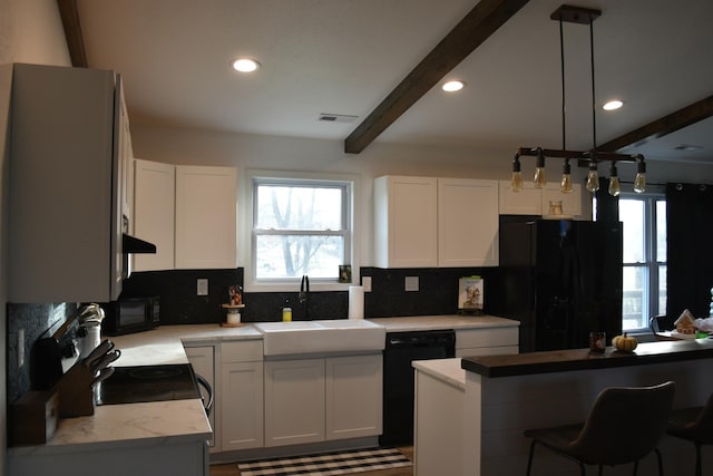 kitchen featuring white cabinetry, sink, hanging light fixtures, beamed ceiling, and black appliances