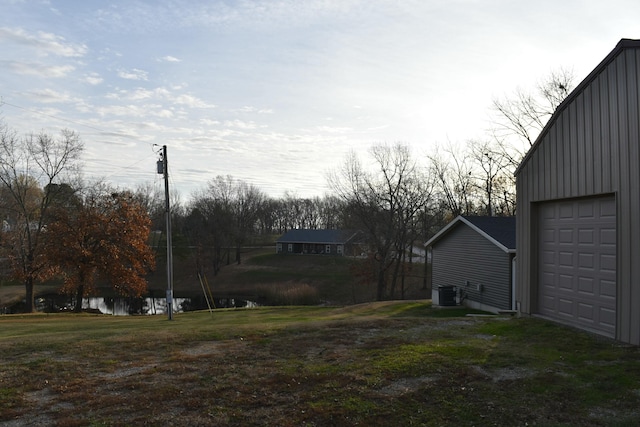 view of yard with central air condition unit and a garage