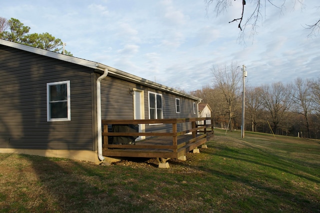 view of side of property with a lawn and a deck