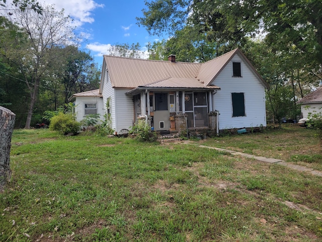 view of front of property with a sunroom and a front lawn