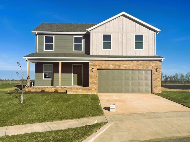 view of front of home featuring covered porch, a garage, and a front yard