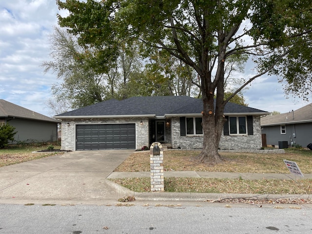 single story home featuring central AC and a garage