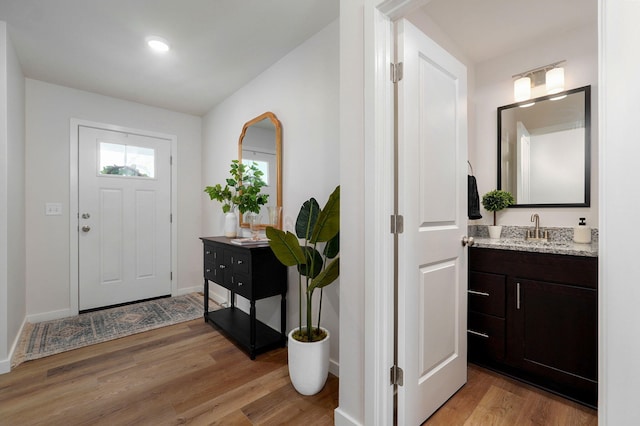 foyer entrance with light wood-type flooring and sink