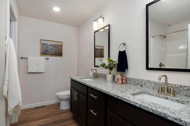 bathroom featuring wood-type flooring, vanity, and toilet