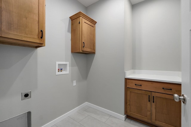 clothes washing area featuring cabinets, washer hookup, electric dryer hookup, and light tile patterned flooring