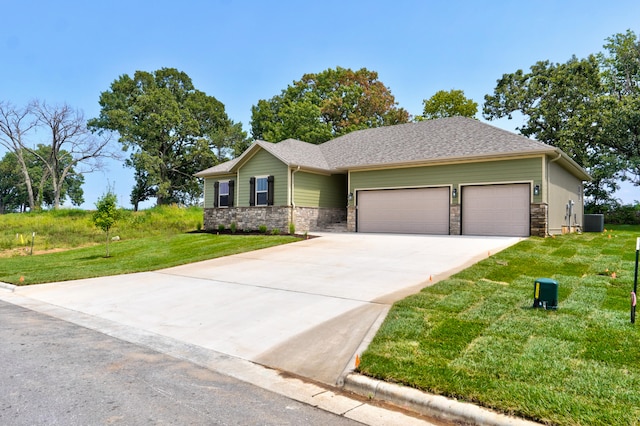 view of front of house with central AC unit, a garage, and a front lawn