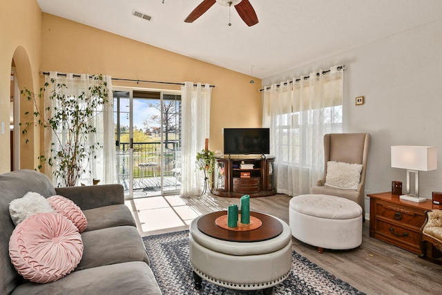 living room featuring hardwood / wood-style flooring, vaulted ceiling, and ceiling fan