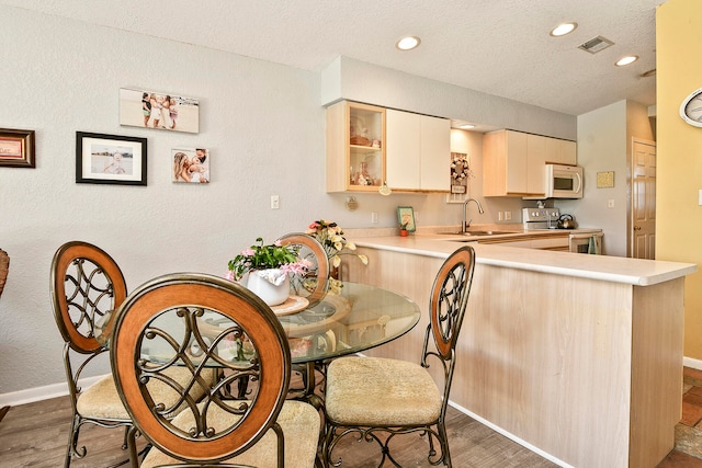 kitchen with electric stove, kitchen peninsula, dark hardwood / wood-style flooring, and sink