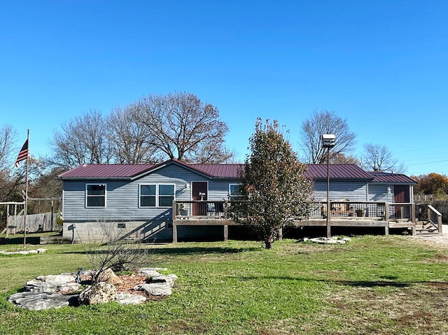 rear view of property with a lawn and a wooden deck