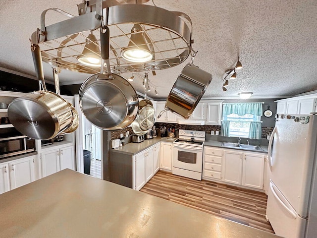 kitchen with white cabinetry, sink, white appliances, and extractor fan