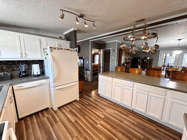 kitchen featuring white cabinetry, light hardwood / wood-style flooring, pendant lighting, white appliances, and backsplash