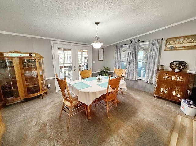 carpeted dining room featuring crown molding, a textured ceiling, and french doors