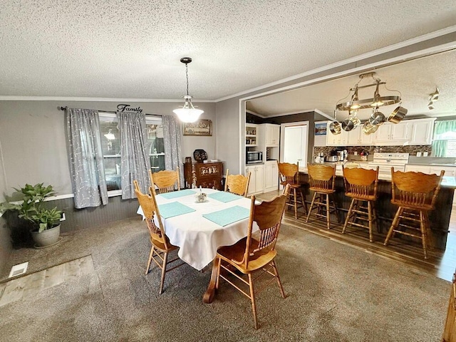 dining space with crown molding, dark carpet, and a textured ceiling