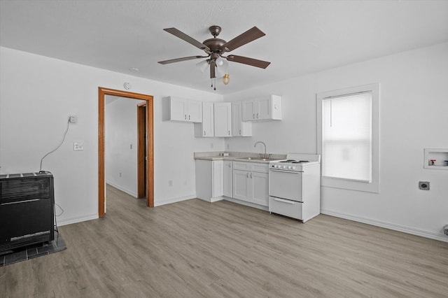 kitchen featuring white stove, white cabinets, ceiling fan, light hardwood / wood-style floors, and heating unit