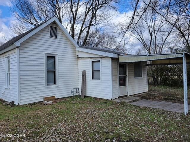 rear view of property featuring a carport