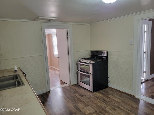 kitchen featuring range with two ovens, crown molding, dark wood-type flooring, and sink