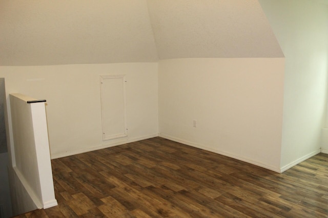 bonus room featuring dark wood-type flooring and vaulted ceiling