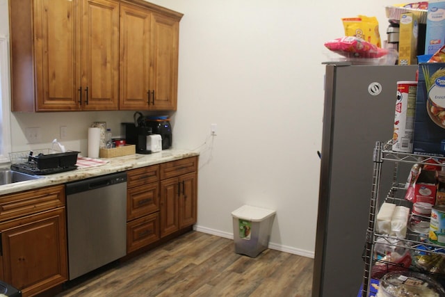 kitchen featuring light stone countertops, appliances with stainless steel finishes, and dark hardwood / wood-style flooring