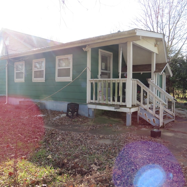 view of side of home featuring covered porch