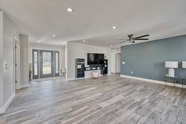 unfurnished living room with ceiling fan and light hardwood / wood-style flooring