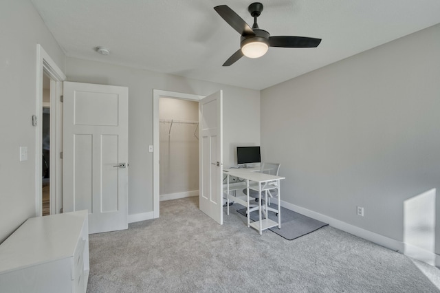 carpeted office space with ceiling fan