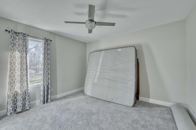 unfurnished bedroom featuring light carpet, a textured ceiling, and ceiling fan