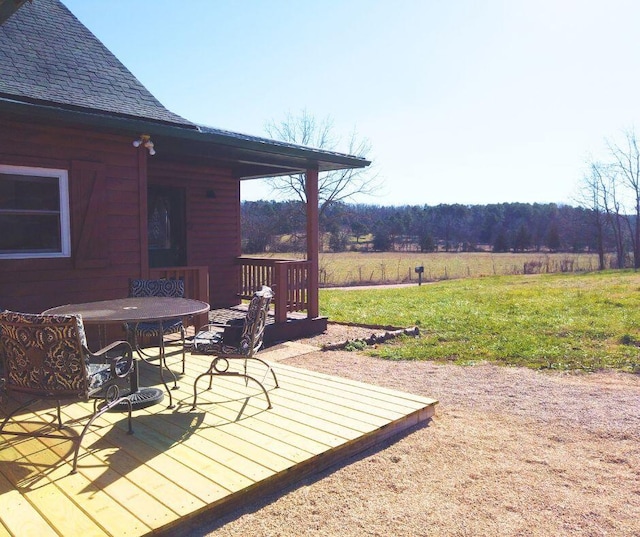 deck featuring a lawn and a rural view