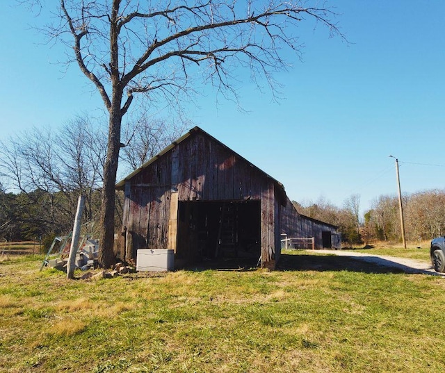 view of home's exterior with a lawn and an outbuilding