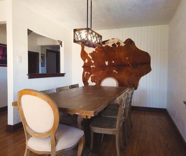 dining space with dark hardwood / wood-style flooring and a textured ceiling