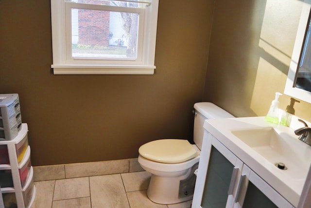 bathroom with toilet, vanity, and tile patterned floors