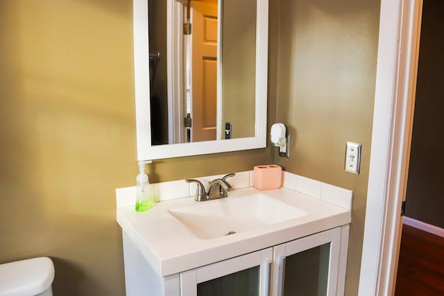 bathroom with vanity, wood-type flooring, and toilet