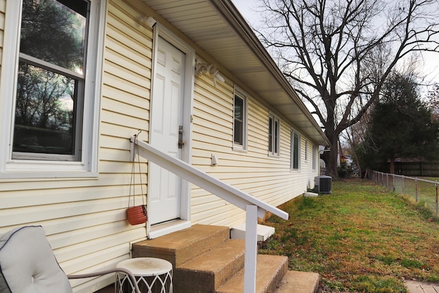 view of side of property with a lawn and cooling unit