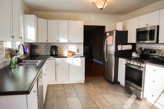 kitchen with appliances with stainless steel finishes, backsplash, white cabinetry, and sink