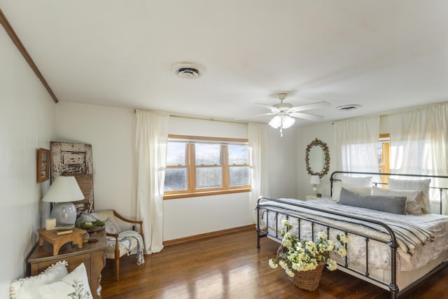 bedroom with dark hardwood / wood-style flooring and ceiling fan