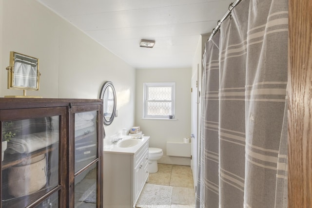 bathroom featuring tile patterned flooring, vanity, toilet, and curtained shower