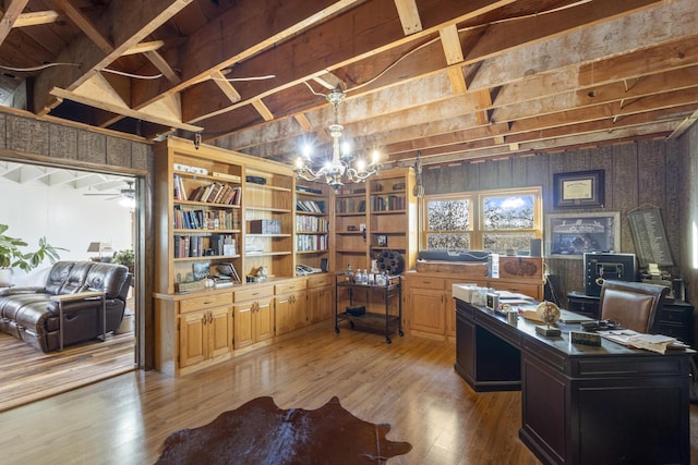 office area with hardwood / wood-style flooring, a notable chandelier, and wooden walls