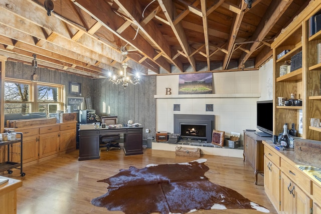 interior space featuring a fireplace, light hardwood / wood-style flooring, and a notable chandelier