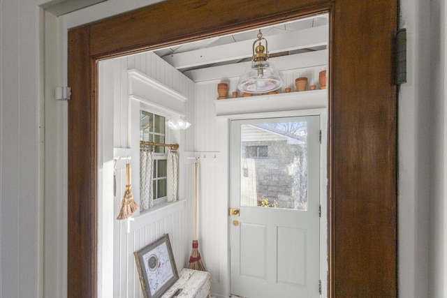 doorway to outside with wooden walls