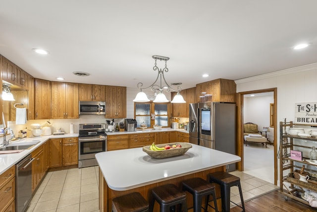 kitchen featuring a center island, sink, stainless steel appliances, and a breakfast bar area